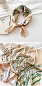 Detail of silk scarf showing ink calligraphy, rabbit and orchid pattern on champagne satin