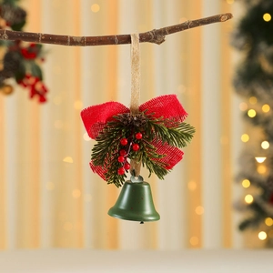 Detailed close-up of iron Christmas bell with red burlap bow and pine cones on a branch
