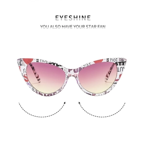 Detail of cat-eye sunglasses featuring colorful letter print on white frames and gradient lenses