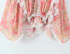 Detalle de tela de gasa floral rosa con ribete de encaje blanco fino en el dobladillo
