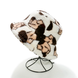 Close-up of plush bucket hat with brown animal spots on a black metal display stand