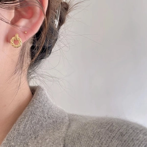 Minimalist gold twisted rope hoop earrings for women showing elegant ear piercing style