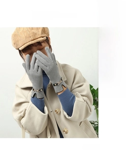 Detail of grey wool gloves featuring an elegant opening and golden horsebit buckle hardware