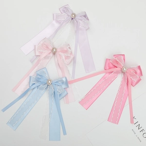 Close-up of colorful ribbon bow hairclips with elegant pearls and lace detailing