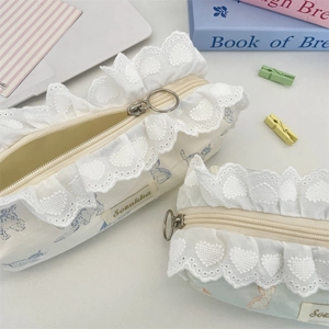 Detailed macro of fabric pencil case with cute cat print and white heart lace trim