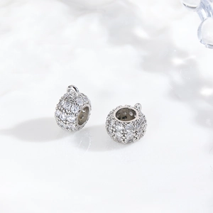 Macro shot of silver cylindrical spacer beads with micro-paved cubic zirconia and loop