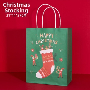 Close-up of green Happy Christmas paper gift bag with festive elf and sock illustrations