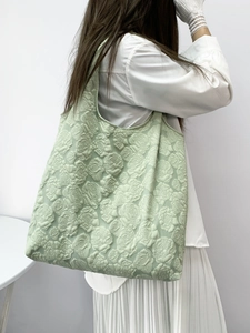 Detail of light green floral embroidery texture on large canvas shopping tote bag