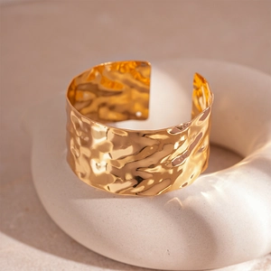 Macro detail of the hammered texture on a polished gold wide open cuff bracelet