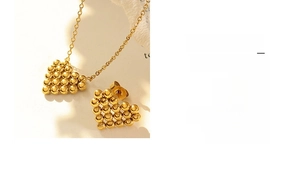 Detail of gold heart necklace and stud earrings set featuring delicate beadwork