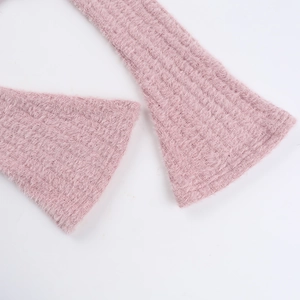 Détail de la texture en maille rose et de la matière pelucheuse de la robe à épaules dénudées