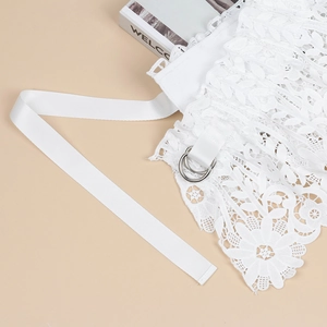 Detail of white floral lace belt with ribbed ribbon strap and silver double D-ring buckle