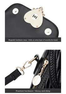 Detailed macro view of gold heart hardware, magnetic snaps, and branded zipper on black leather