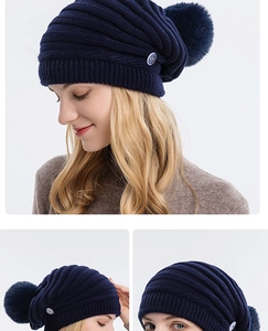 Gros plan sur un bonnet en tricot bleu marine avec un grand pompon et un bouton argenté