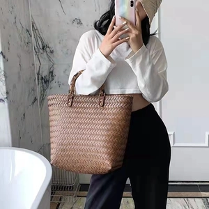 Close-up of the woven texture and bamboo handles on this vintage brown tote bag