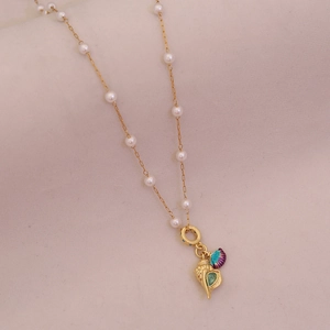 Detail of golden seashell and iridescent scallop pendant on pearl necklace
