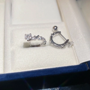 Macro shot of silver U-shaped earrings with zircon and secure screw-back design