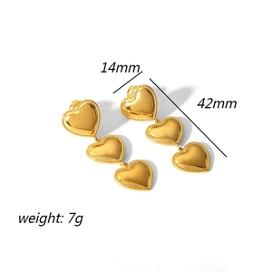 Detail showing 42mm length and 14mm width of triple heart titanium steel gold earrings