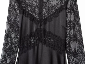Detailed close-up of delicate black lace patchwork on a sleek satin long sleeve dress