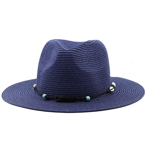Détails d'un chapeau en paille bleu marine avec perles turquoise et coquillages