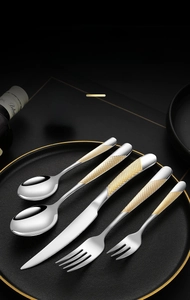 Macro view of luxury stainless steel flatware set with golden diamond pattern handles