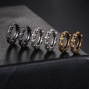 Macro shot of punk skull hoop earrings in vintage silver, black, and bronze metal finish