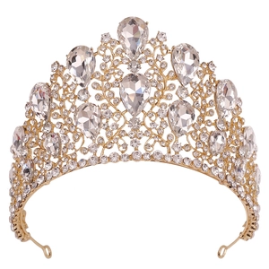 Close-up of golden baroque tiara with water-drop crystals and floral rhinestones