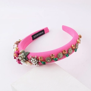 Detailed macro view of pink fabric headband with handmade pearls and floral crystal jewels