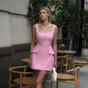 Dettaglio dell'abito corto rosa con scollo quadrato e tasche con patta laterali all'aperto