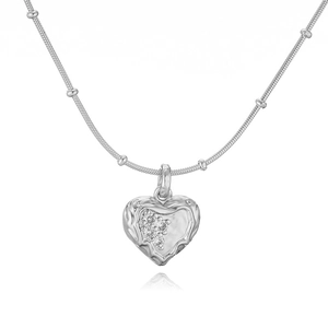 Macro detail of silver heart necklace with lava texture and sparkling cubic zirconia stones