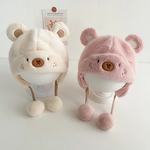 Dettaglio del cappello in peluche per neonati con orecchie d'orso e paraorecchie in beige e rosa
