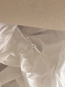 Detail view of a 925 sterling silver bow knot ring on elegant gift packaging material