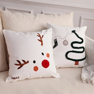 Christmas pillow set with 3D reindeer embroidery and festive tree design on sofa