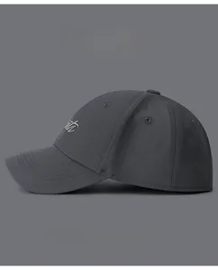 Detail of grey baseball cap showing white embroidery and curved brim with stitching