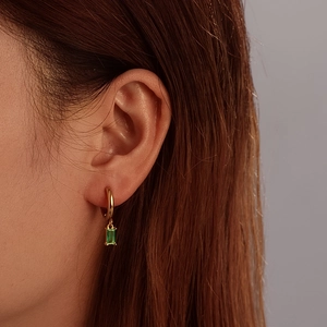 Elegant gold hoop earrings with green rectangular gemstone pendants on female model