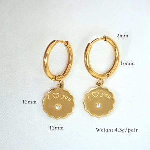 Detail of gold hoop earrings with I love you floral pendant and sparkling crystal accent