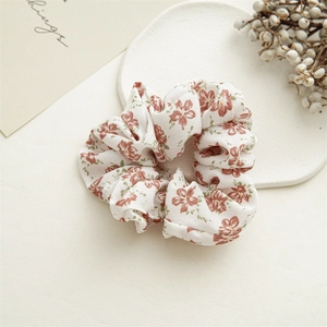 Detail of floral printed fabric hair scrunchie with vintage blossom pattern and soft texture