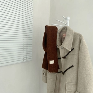 Soft wool blend solid brown scarf paired with a beige duffle coat on a hanger