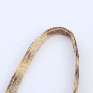 Macro shot of leopard print mesh strap with vibrant yellow stitching and fabric detail