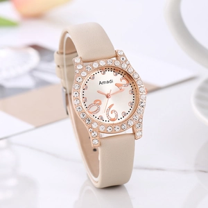 Montre Amadi pour femme avec lunette en strass et bracelet en cuir beige sur fond marbre