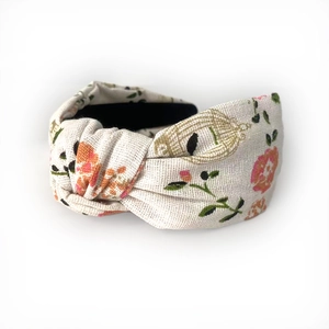 Detail of linen headboard with pink floral patterns and a handcrafted knot design