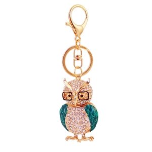 Porte-clés chouette doré avec ailes en émail vert et cristaux sur fond beige