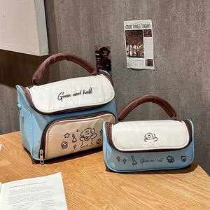 Detail of blue canvas cosmetic bags set with dog print and brown handles on wooden table