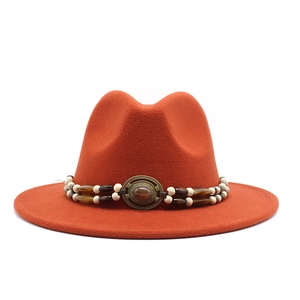 Detail of orange wool felt fedora featuring bohemian beaded band and vintage metal buckle
