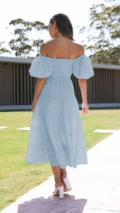 Back view of light blue off-shoulder tiered dress with puff sleeves and layered skirt