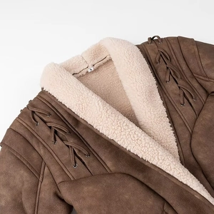 Detail of faux shearling collar and brown suede texture with lace-up shoulder design