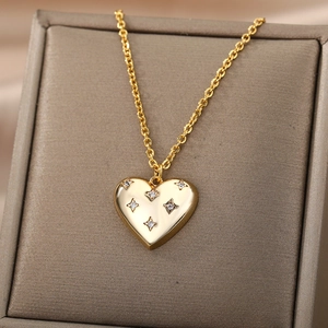 Macro shot of gold heart necklace with star-shaped crystal inlay on jewelry box