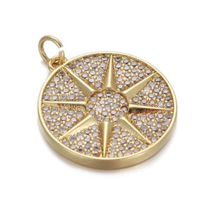 Detail of a gold-plated circular pendant with a starburst design and clear zircon stones