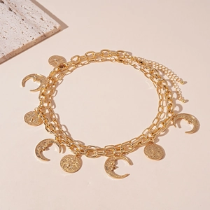 Detail of double-layer gold celestial necklace with sun and moon relief charms
