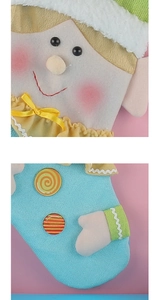 Close-up of fabric Christmas stocking with embroidered face, ribbon bow and textures